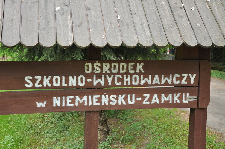 Tablica informacyjna przy wjeździe do pałacu myśliwskiego 