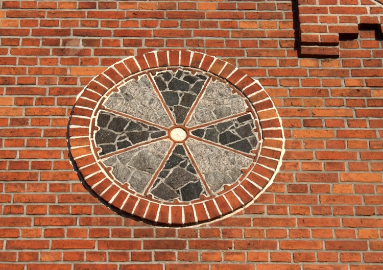 Krzyż słoneczny  umieszczony na ścianie plebani 