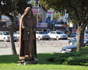 Zdjęcie przedstawia drewnianą rzeźbę średniowiecznego woja na rynku w Wolinie                                                                                                                           