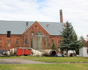 Zdjęcie przedstawia dawny folwark w Witnicy. Na pierwszym planie widać podwórko gospodarcze, w tle budynek z zespołu folwarcznego.                                                                      
