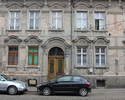 Zdjęcie przedstawia dom mieszkalny przy ul. Jana Pawła II 14 w Mieszkowicach. Na pierwszym planie widać frontową elewację budynku z wejściem w centralnej części.                                       