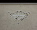 Zdjęcie przedstawia fragment elewacji urzędu gminy w Widuchowej. Na pierwszym planie widać mieszczący się nad wejściem do obiektu symbol masonerii.                                                     