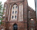 Zdjęcie przedstawia jeden z budynków wchodzących w skład dawnego klasztoru cystersów w Kołbaczu. Na pierwszym planie widoczna jest tylna elewacja kościoła.                                             