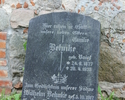 Zdjęcie przedstawia płytę nagrobną z cmentarza przykościelnego w Borzymie. Na pierwszym planie widoczna jest niemiecka płyta oparta o ścianę kościoła, inskrypcja na płycie jest czytelna.              