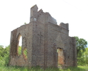 Zdjęcie przedstawia ruiny kościoła w Krajniku Dolnym. Na pierwszym planie widać frontową ścianę i fragment bocznej.                                                                                     