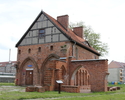Zdjęcie przedstawia dom opata z dawnego klasztoru cystersów w Kołbaczu. Na pierwszym planie widoczne jest wejście do domu oraz fragmenty nieistniejącego skrzydła.                                      