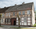 Zdjęcie przedstawia domy ryglowe w Widuchowej. Na pierwszym planie widać dom mieszczący się przy ul. grunwaldzkiej 27, w tle po lewej stronie widoczny jest fragment domu nr 25.                        