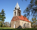 Zdjęcie przedstawia kościół od strony wejścia, który został wykonany z szarej cegły.                                                                                                                    