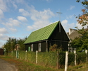 Zdjęcie przedstawia stronę wejściową kościoła otoczonego dookoła zielenią.                                                                                                                              