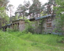 Na zdjęciu znajdują się ruiny budynku z jedną kondygnacją, otoczonego lasem.                                                                                                                            