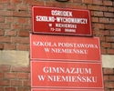 Zdjęcie przedstawia tablice informujące o siedzibie szkoły oraz Ośrodka Szkolno Wychowawczego w pałacu myśliwskim                                                                                       