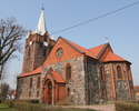 Zdjęcie przedstawia ścianę boczną oraz tył kościoła zbudowanego z kamienia i cegły.                                                                                                                     