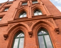 Zdjęcie przedstawia Ratusz Czerwony w Szczecinie. Na pierwszym planie widać ozdobne łuki nad oknami.                                                                                                    