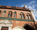 Zdjęcie przedstawia Ratusz Staromiejski w Szczecinie. Na pierwszym planie widać boczną elewację z cegły, w dole zdjęcia uchwycono fragment wejścia do budynku i krużganku.                              