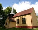 Na zdjęciu znajduje się tył oraz ściana boczna kościoła, którego wieża ma konstrukcje drewnianą.                                                                                                        