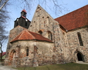 Zdjęcie przedstawia kościół zbudowany z jasnej cegły od strony bocznej.                                                                                                                                 