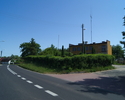 Zdjęcie przedstawia dojazd do budynku Straży Gminnej i Policji w Postominie. Budynek znajduje się z prawej strony w głębi ulicy.                                                                        
