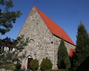 Zdjęcie przedstawia stronę wejścia kościoła zbudowanego z kamienia.                                                                                                                                     