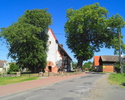 Zdjęcie przedstawia drogę wraz z zabudowaniami oraz kościołem przebiegającą przez wieś Staniewice.                                                                                                      