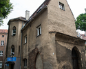 Zdjęcie przedstawia krużganek Mariacki w Szczecinie. Na pierwszym planie widać boczną i frontową elewację budynku.                                                                                      