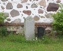 Zdjęcie przedstawia cmentarz przykościelny w Steklnie. Na pierwszym planie widać dwa niemieckie nagrobki na tle ściany kościoła.                                                                        