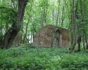 Zdjęcie przedstawia ruiny kościoła w Raduniu. Na pierwszym planie widać frontową elewację kościoła, w centralnej części ściany otwór wejściowy.                                                         