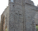 Zdjęcie przedstawia ruiny kościoła w Krajniku Dolnym. Na pierwszym planie widać frontową ścianę i wgłębienie w kształcie krzyża.                                                                        