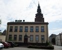 Zdjęcie przedstawia teren starego miasta w Gryfinie. Na pierwszym planie widać gmach biblioteki miejskiej, nad nim wieża kościoła.                                                                      