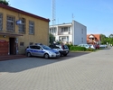 Zdjęcie drogi dojazdowej do komisariatu wraz z frontem budynku i apartamentami do wynajęcia w jego sąsiedztwie                                                                                          