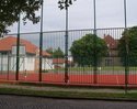 Zdjęcie przedstawia boczną stronę budynku oraz przyległe boiska.                                                                                                                                        