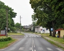 Zdjęcie przedstawia widok na jedną z ulic w Kłodkowie oraz przystanek autobusowy wraz z budynkami sąsiadującymi                                                                                         