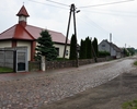 Zdjęcie przedstawia brukowaną uliczkę oraz znajdujący się przy niej kościół                                                                                                                             
