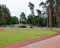 zdjęcie przedstawia bieżnię lekkoatletyczną, kawałek lasu oraz skatepark w oddali                                                                                                                       