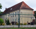 Zdjęcie przedstawia widok na bramę oraz pałac znajdują się w oddali                                                                                                                                     