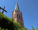 Zdjęcie przedstawia widok z bliskiej perspektywy wieży kościoła PW NMP w Połczynie-Zdroju.                                                                                                              