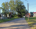 Zdjęcie przedstawia skrzyżowanie dróg na Dołganów i Głodzino z zabudowaniami w Kłodzinie.                                                                                                               