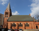 Na zdjęciu znajduje się ściana boczna kościoła, który został zbudowany z cegły.                                                                                                                         