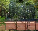 Zdjęcie przedstawia korty tenisowe otoczone parkowymi drzewami w Połczynie-Zdroju. Widok od strony sanatorium Podhale.                                                                                  