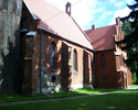 Zdjęcie przedstawia drewnano-kamienno-ceglany kościół w Sadlnie.                                                                                                                                        