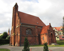 Zdjęcie przedstawia  kościół z czerwonej cegły.                                                                                                                                                         