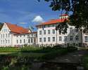 Zdjęcie przedstawia pałac w Rzepczynie w widoku od strony południowej. Na pierwszym planie widoczne alejki i klomby dziedzińca pałacowego.                                                              