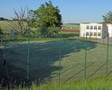 Zdjęcie przedstawia boisko Orlik w Rąbinie w widoku od strony południowej. W tle widoczny zespół szkół.                                                                                                 