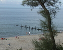 Zdjęcie przedstawia fragment plaży wraz z falochronem.                                                                                                                                                  