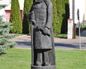 Zdjęcie przedstawia drewnianą rzeźbę średniowiecznego woja na rynku w Wolinie                                                                                                                           