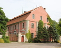 Zdjęcie przedstawia pałac w Lubiechowie Górnym. Na pierwszym planie widać frontową i boczną elewację budynku. Boczna część jest nieco przysłonięta przez drzewa.                                        