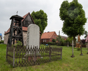 Zdjęcie przedstawia cmentarz przykościelny w Mielenku Gryfińskim. Na pierwszym planie widać pomnik poświęcony ofiarom I wojny światowej. Po prawej stronie żeliwne krzyże.                              