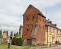 Zdjęcie przedstawia basztę więzienną w Kołbaczu. Na pierwszym planie widać budowlę, w głębi, z prawej strony widoczny jest przylegający do baszty sklep.                                                