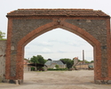 Zdjęcie przedstawia folwark w Krzymowie. Na pierwszym planie widać bramę, w głębi podwórze gospodarcze i pałac.                                                                                         