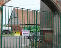 Zdjęcie przedstawia stodołę gotycką w Kołbaczu. Na pierwszym planie widoczna jest brama, która prowadzi na prywatny teren, na którym znajduje się zabytek.                                              