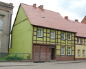 Zdjęcie przedstawia dom mieszkalny przy ul. Sienkiewicza 54 w Mieszkowicach. Na pierwszym planie widać frontową, ryglową elewację budynku.                                                              